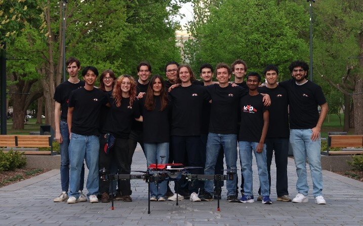 Full McGill Aerial Design team posing with a quadcopter drone in a park