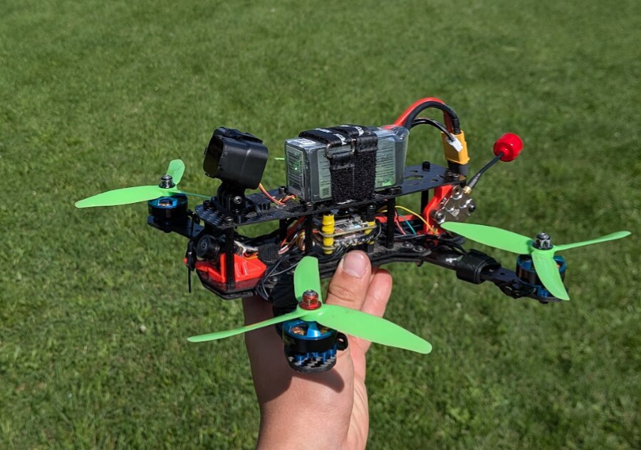 5-inch FPV drone held up in a backyard, ready to fly