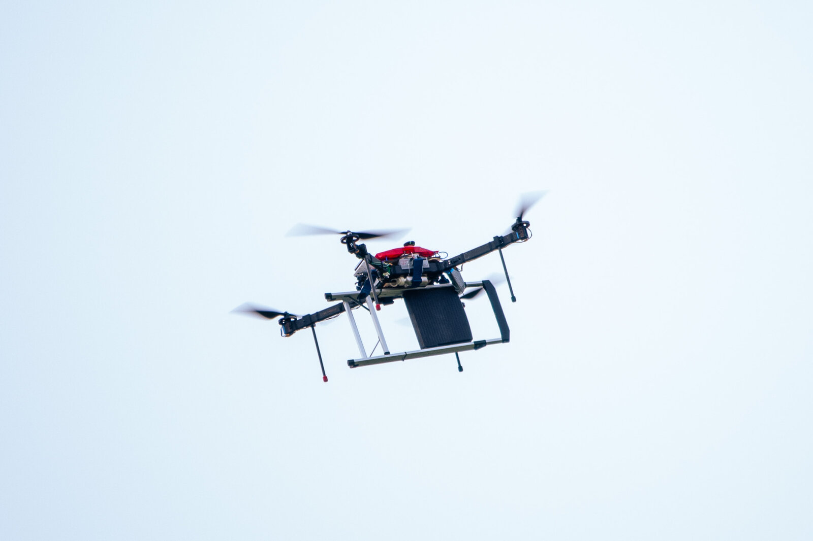 MegaQuad in flight against a plain sky, low-angle shot