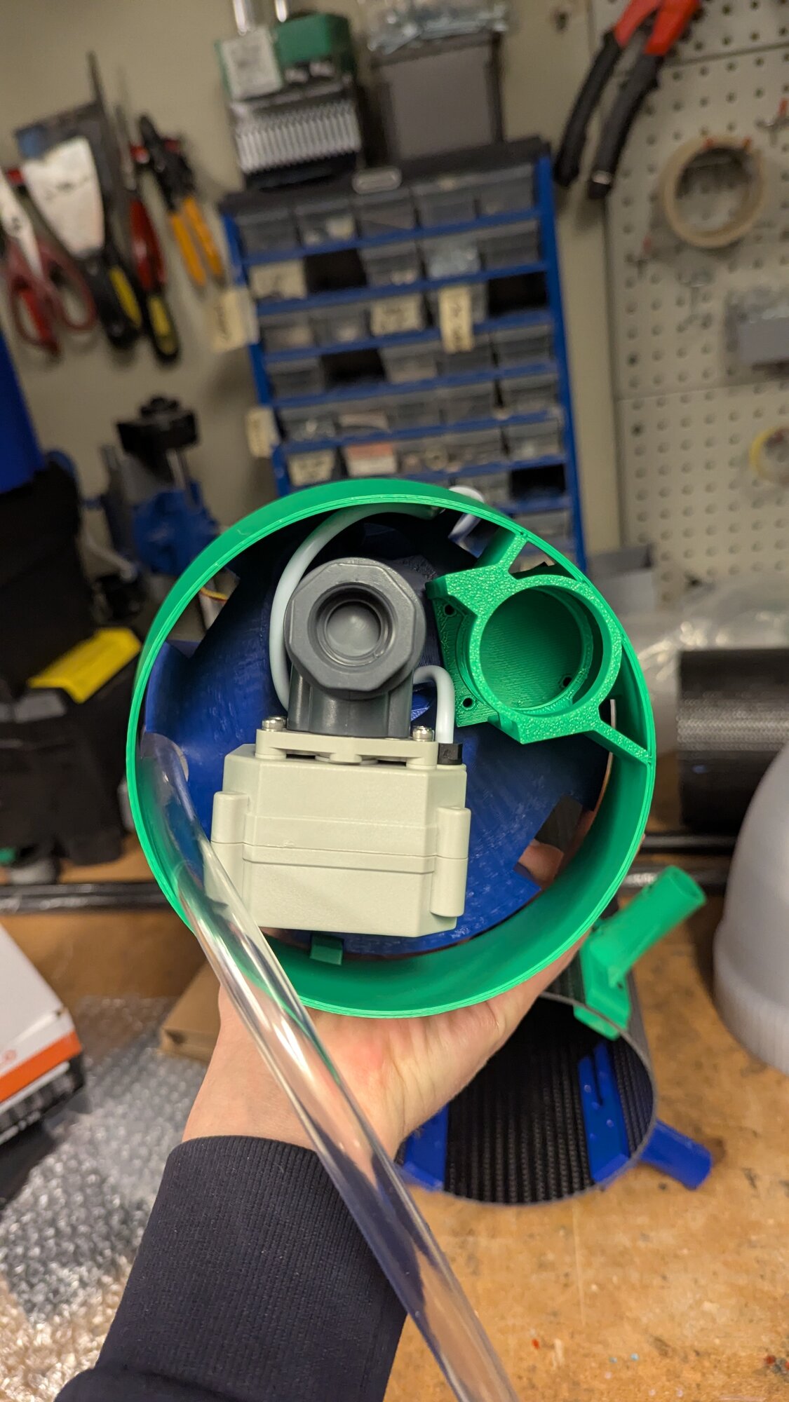 Close-up looking into the bottom of the tank at the gray solenoid valve, wiring, and green 3D printed mount