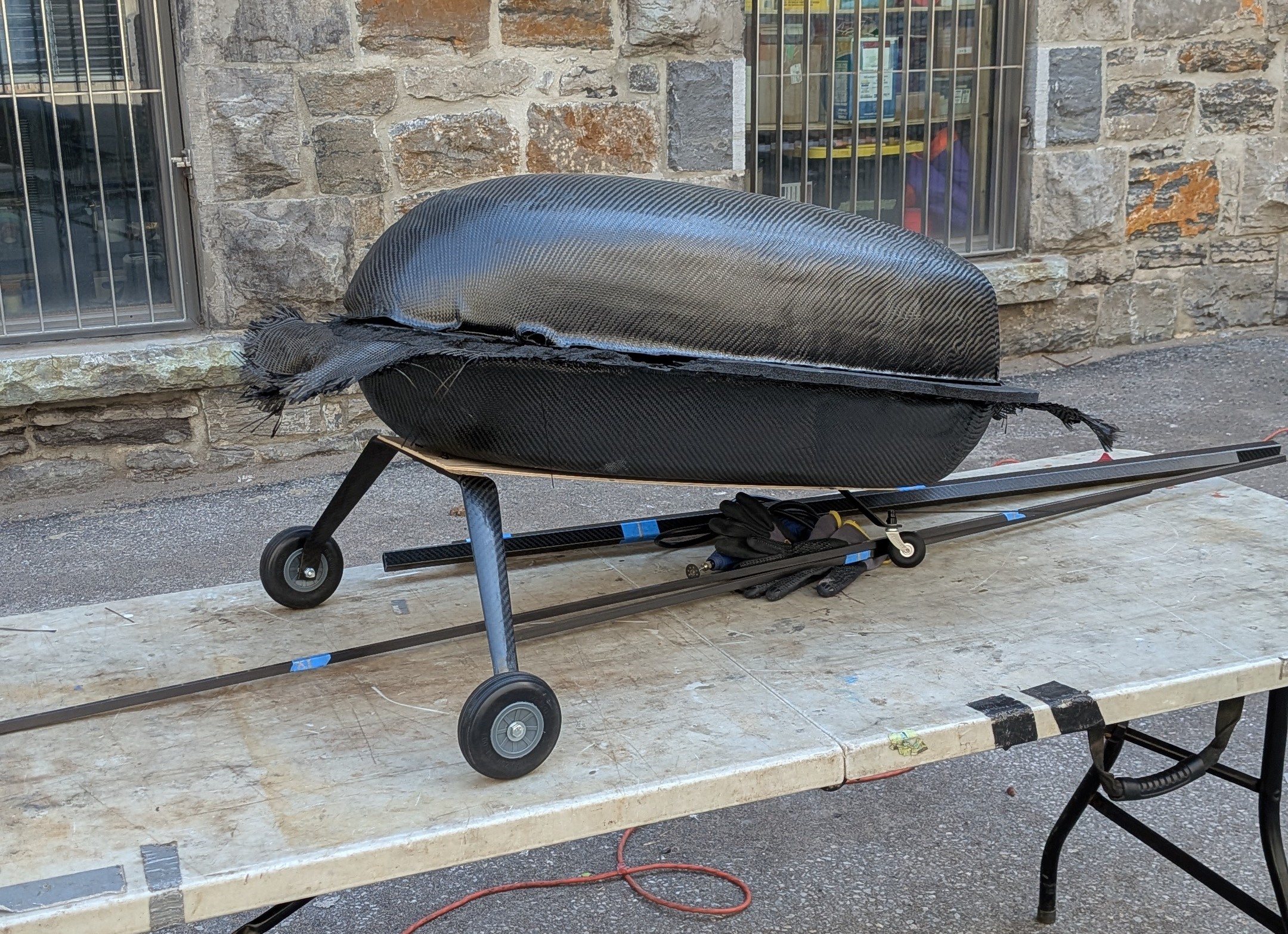 Carbon fiber fuselage pod resting on a rolling cart